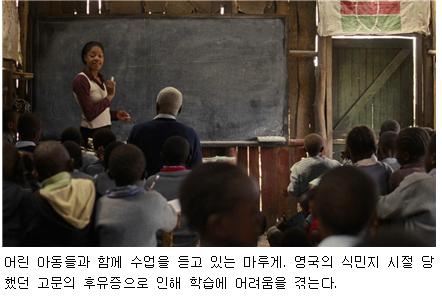 어린 아동들과 함께 수업을 듣고 있는 마루게. 영국의 식민지 시절 당했던 고문의 후유증으로 인해 학습에 어려움을 겪는다.