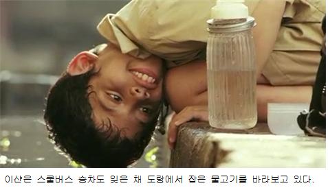 이샨은 스쿨버스 승차도 잊은 채 도랑에서 잡은 물고기를 바라보고 있다.