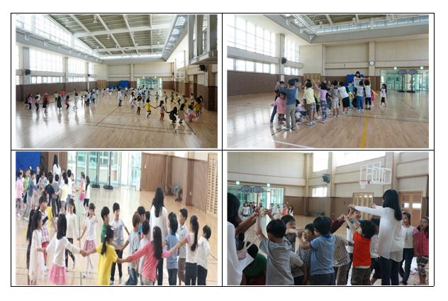 강당에서 약 90여명의 아이들이 강강술래하는 사진 두 장과 청어엮기 놀이를 하는 사진 두 장이 있습니다.